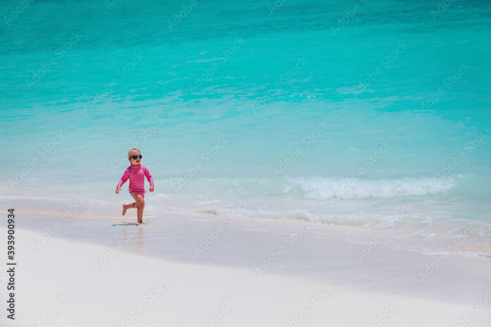 cute happy little girl running on beach