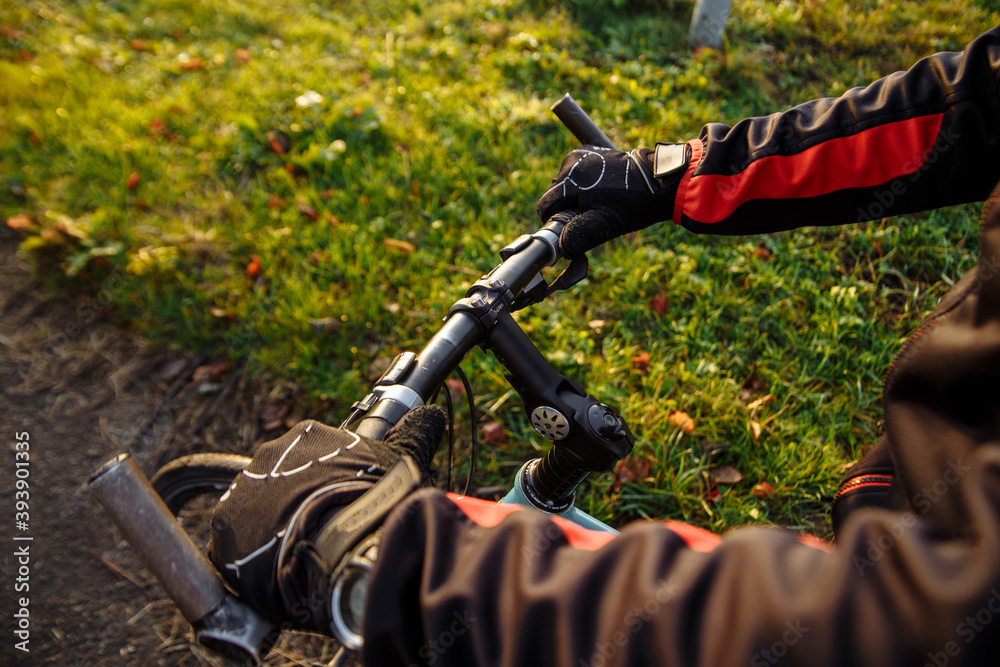 Naklejka premium cyclist in black clothes and helmet trains on a bicycle
