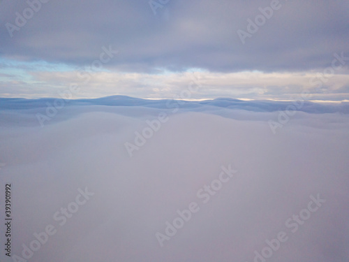 High aerial flight between fog and clouds.