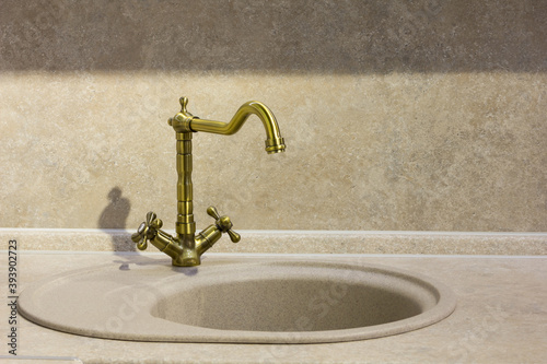 round porcelain tile kitchen sink on the kitchen countertop and retro brass faucet