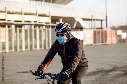 cyclist during quarantine rides a bicycle in a mask