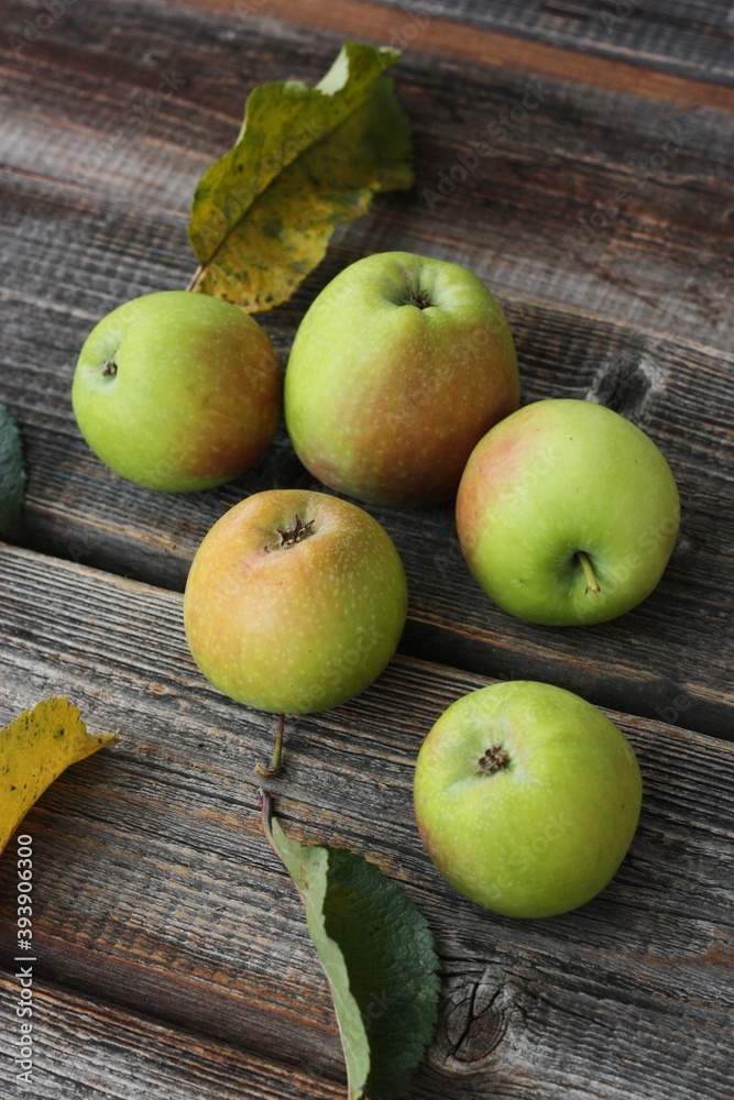 Green apples and autumn leaves on the table Green apples and autumn leaves on the table