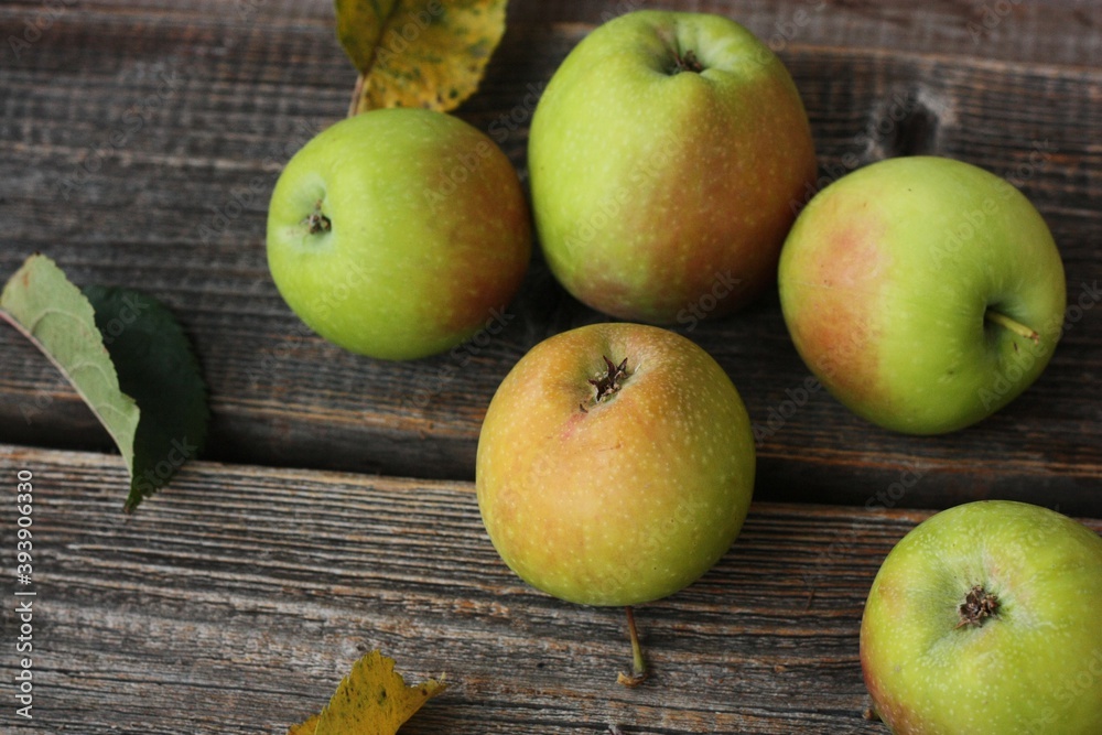 Green apples and autumn leaves on the table Green apples and autumn leaves on the table