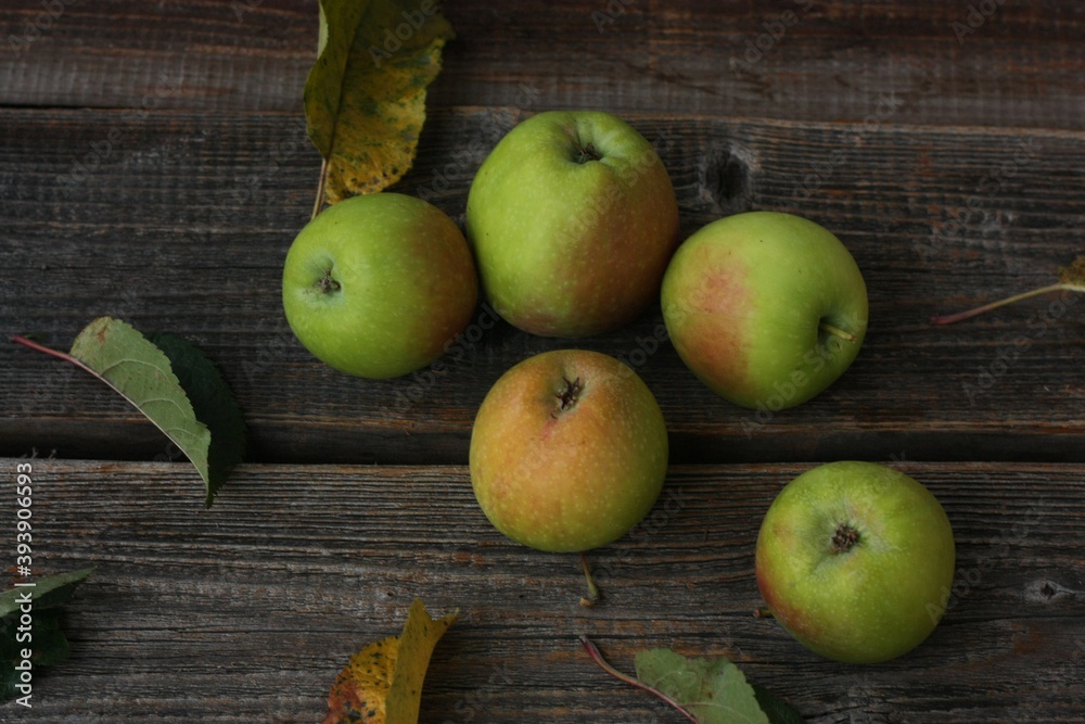 Green apples and autumn leaves on the table Green apples and autumn leaves on the table