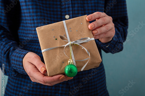 Hald holding small girt box with green Christmas bauble photo