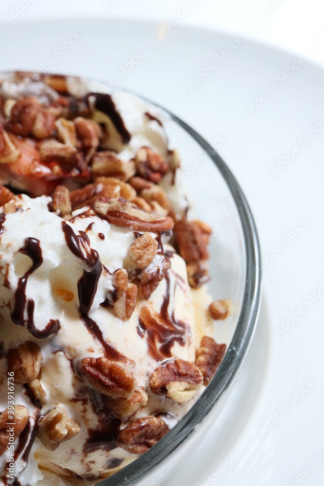 close up de una taza de helado con salsas y frutos secos