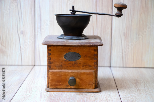 coffee grinder and coffee beans on a white wood background