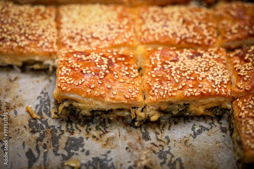 Burekas. Puff pastry pies with spinach with spinach, salted cheese, and sesame