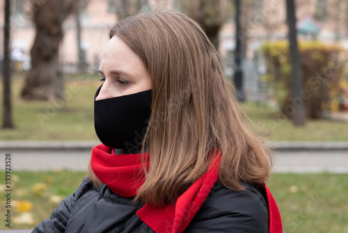 portrait of a young woman in protective mask outdoors in the park