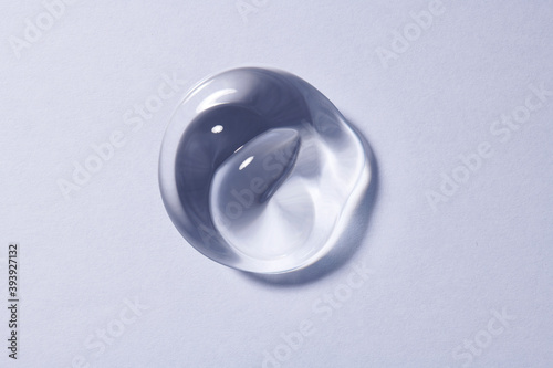 Blob of clear gel texture similar to antibacterial hand lotion or hydroalcoholic gel. Single dollop of transparent texture on even surface.  photo
