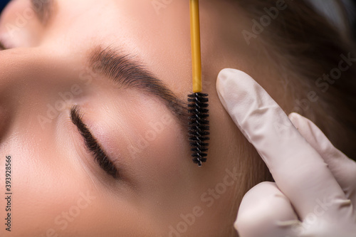 Permanent eyebrow makeup. Cosmetologist applying tattooing of eyebrows. © Ludaiv