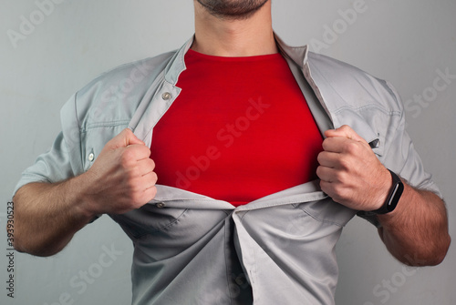 Super man in red rips the shirt on his chest