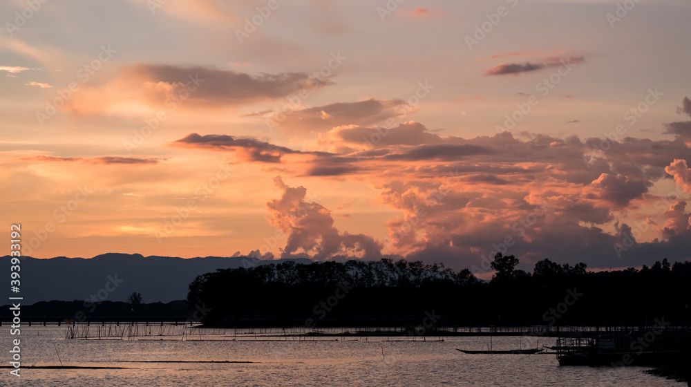 A Silhouette Fisherman row boat in Phayao Lake. Scenery sunset in Phayao Province , Thailand.
