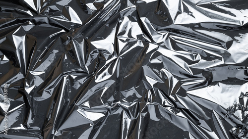 Plastic wrap. Black shiny film bag pattern. Transparent dark cellophane texture. Creative crumpled background.