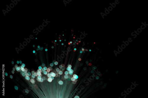 Fiber optic abstract neon lights colorful background. Close up view with bokeh. Glowing optical fibers. Abstract image with copy space.
