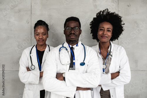 Group of Afro American doctors with protective face masks standing and looking at camera. Healthcare, pandemic, coronavirus (Covid-19) concept. photo