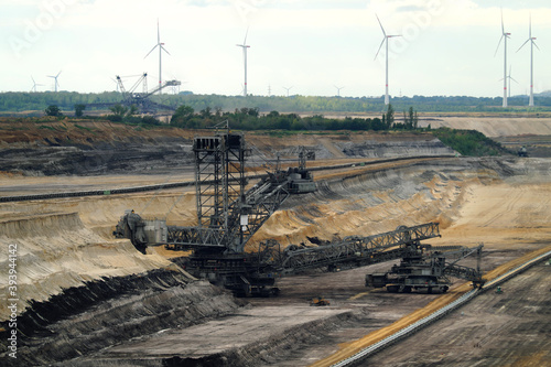 Strip mine with bucket excavator for brown coal mining and wind wheels in the background - stockphoto photo