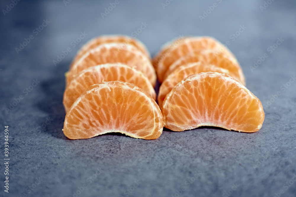 A shot of tangerine pieces on a rough surface