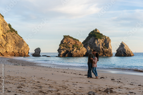 Couple kissing on a wild empty beach in Ribeiro do Cavalo, Arrabida, Portugal