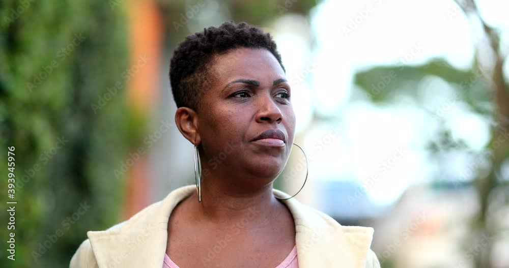 Confident serious African woman 40s walking towards camera in street Confident serious African woman 40s walking towards camera in street