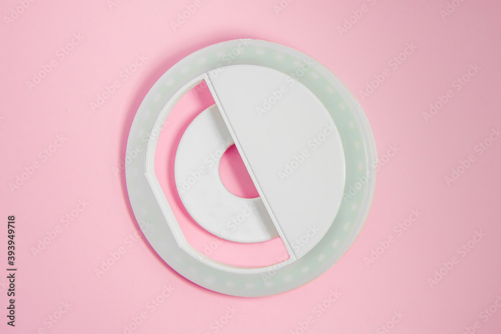 Close-up LED selfie circular ring light lamp on pink background. Clip-on flash light camera phone for taking selfie photos and videos. Compact and lightweight device for bloggers and vloggers. Close-up LED selfie circular ring light lamp on pink background. Clip-on flash light camera phone for taking selfie photos and videos. Compact and lightweight device for bloggers and vloggers.