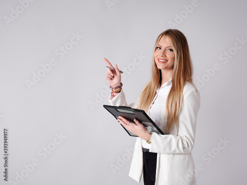 Young business woman pointing and taking notes in a folder