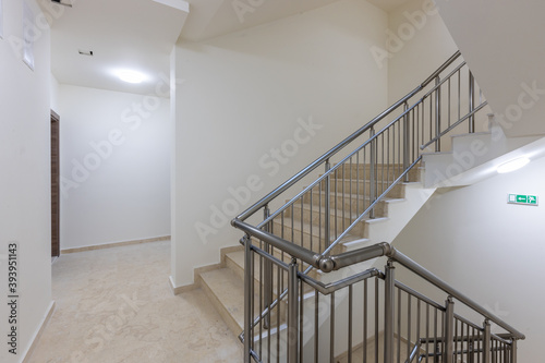 Modern stair case between floors. Stairs with metallic rail  in modern building photo