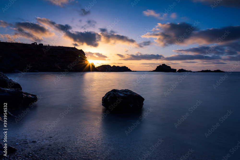 Naklejka premium Beautiful and colorful sunrise from a rocky beach in Cabo de Palos, Murcia, Spain