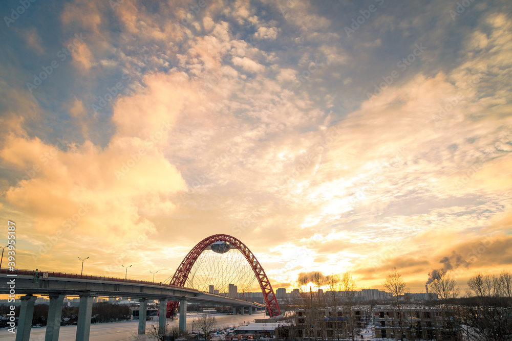 Obraz premium Zhivopisny suspension bridge winter sunset landscape in Moscow, Russia. Red beautiful modern suspension bridge 