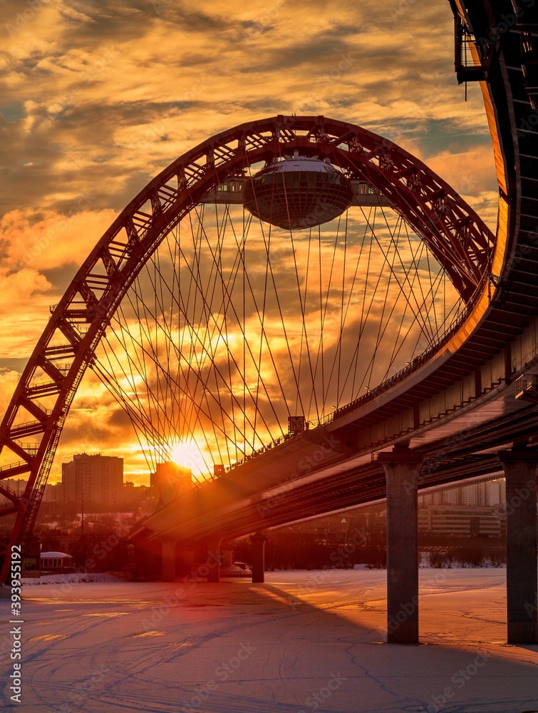 Obraz premium Zhivopisny suspension bridge winter sunset landscape in Moscow, Russia. Red beautiful modern suspension bridge 