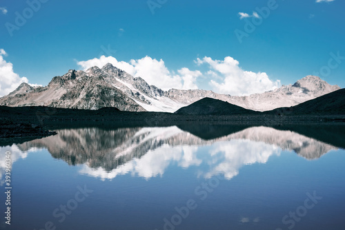 Beautiful landscape of snow-capped mountains and reflections in the lake. The concept of mountain climbing and extreme recreation