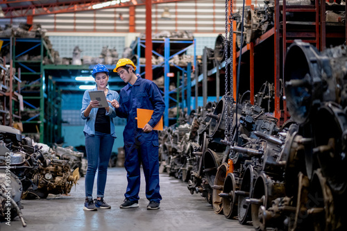 Canvastavla Soft blur of couple Asian factory man and woman workers discuss together stand in automotive parts workplace area