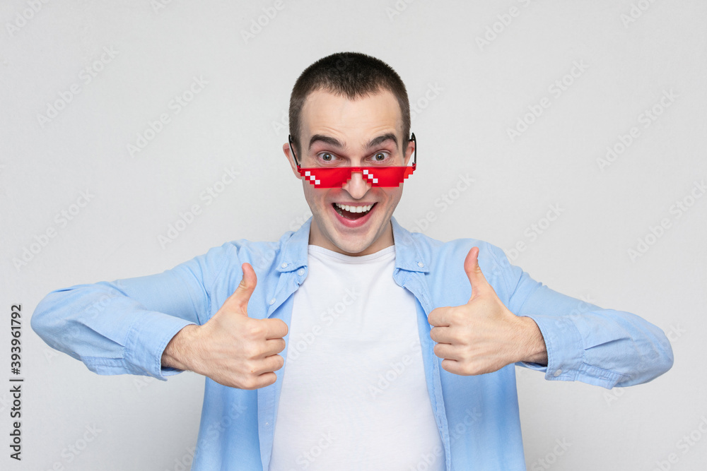 Film fan in red pixels glasses showing thumbs up, portrait, white background Film fan in red pixels glasses showing thumbs up, portrait, white background