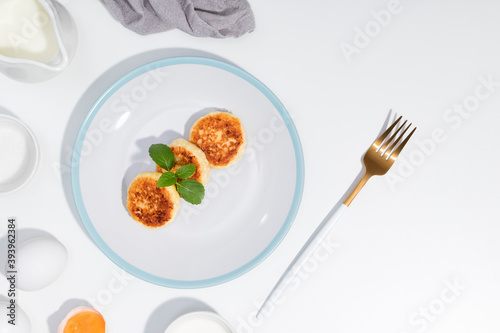 Cottage cheese  eggs  cream and yougurt on a white background - Flat lay with curd pancake - Recipe
