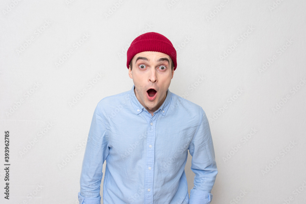 Surprised guy in a red cap and blue shirt looks at the camera, portrait Surprised guy in a red cap and blue shirt looks at the camera, portrait