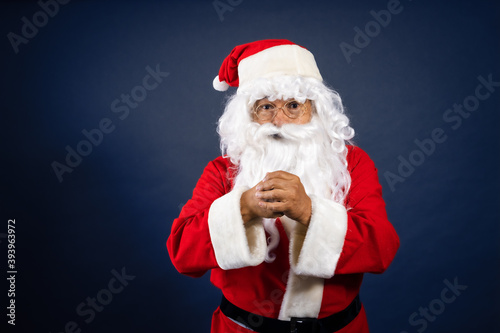 Retrato de papa noel señalando ofertas en traje típico navideño