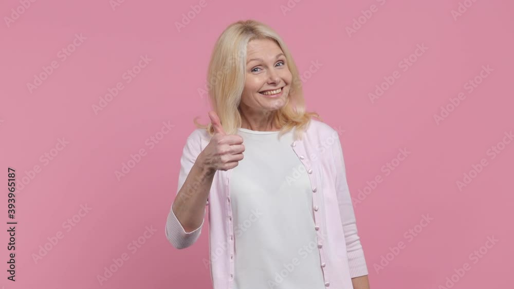 Smiling elderly gray-haired blond woman lady 40s 50s years old wearing white blank casual t-shirt try to hear you overhear listening intently say wow isolated on pastel pink background studio portrait Smiling elderly gray-haired blond woman lady 40s 50s years old wearing white blank casual t-shirt try to hear you overhear listening intently say wow isolated on pastel pink background studio portrait