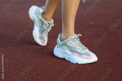 female feet wearing sport shoes  outdoors on sport ground