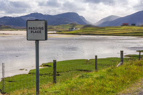 Beautiful Scottish scenery of Passing Place sign in front of Uig beach with hills and glens in the distance.  photo