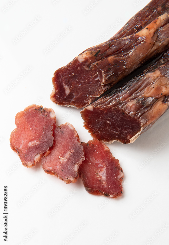 Dried sausage sliced into slices on a white plate. Elite meat product Dried sausage sliced into slices on a white plate. Elite meat product