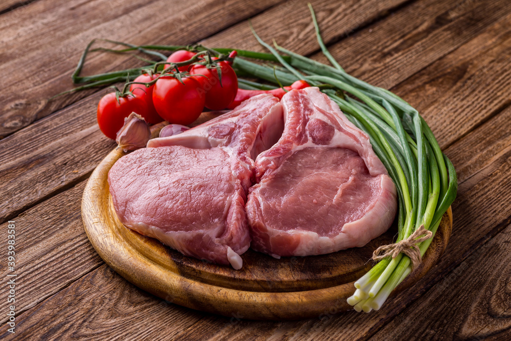 fresh raw new-york steak on wooden Board on wooden background with salt and pepper in a rustic style.