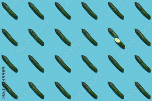 a pattern of cucumbers on a blue background. modern pattern. Healthy vegetarian food. flat lay