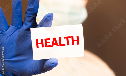 Doctor holding a card with text HEALTS in both hands. Medical concept, photo