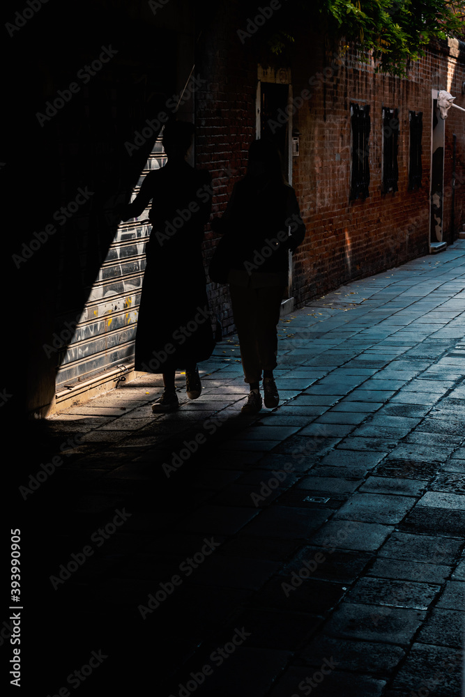 silhouette of two women walking on the streets of Venice silhouette of two women walking on the streets of Venice