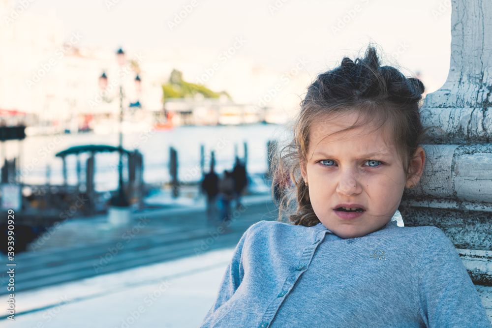 portrait of a cute little girl with blue eyes posing on the streets of Venice Italy