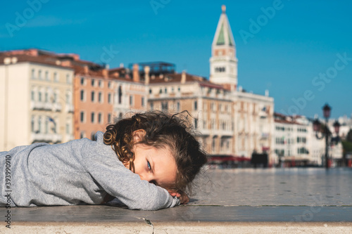 portrait of a cute little girl with blue eyes posing on the streets of Venice Italy © Florincristian