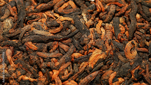 Chinese extruded tea ripe puer high quality with red tea buds. Macro image with blurred background.