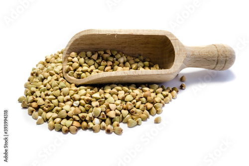 Buckwheat grains with wooden scoop isolated on white background