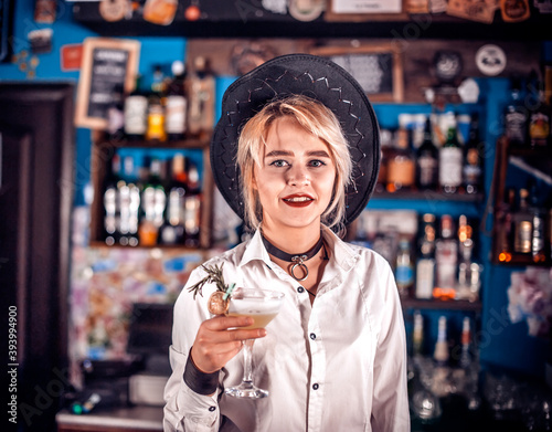 Girl bartender mixes a cocktail on the beerhall photo