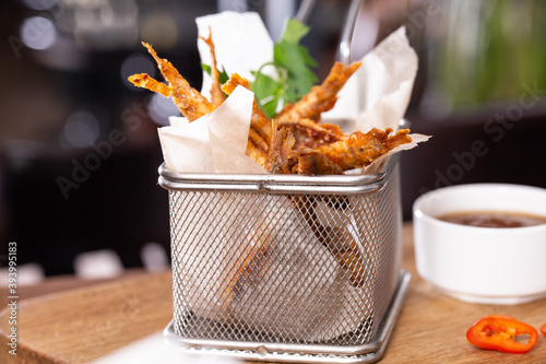 Roasted red mullet fish in deep-frying basket on a wooden table. Depth of field